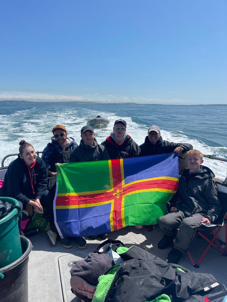 A boatful of happy swimmers with a lincolnshire flag